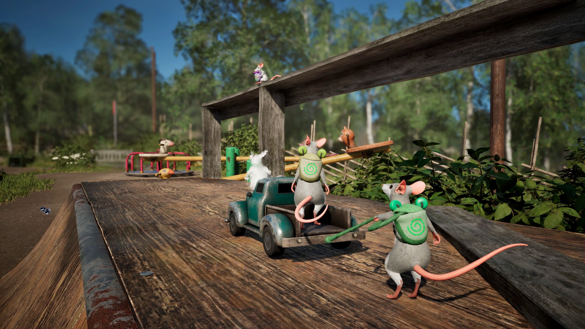 Vier Mäuse auf einem Spielplatz mit einem kleinen Wagen, wo eine Maus schiebt, zwei drauf stehen und eine daneben auf einem Gelände steht.